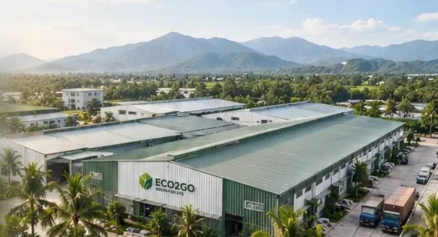 Aerial view of the Eco2go factory surrounded by palm trees and mountains