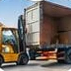 Forklift loading cartons into a shipping container